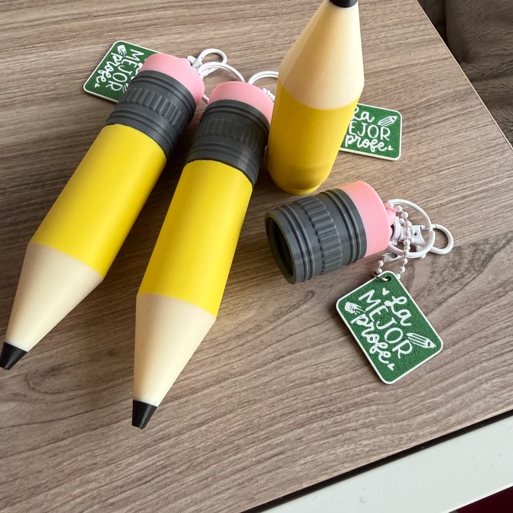 Estuches cilíndricos con diseño exterior de lápiz y sacapuntas sobre escritorio