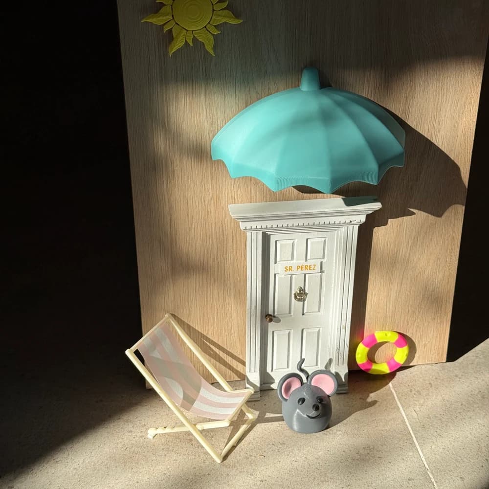 Composición en miniatura con puerta rotulada, sombrilla y accesorios de playa